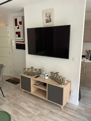 a living room with a flat screen tv on a wall at Studio coin nuit terrasse parking Clim in Nice