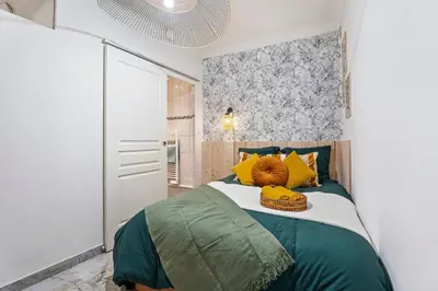 a bedroom with a bed with yellow and green pillows at Nice Renting - FODERE - Charm & Comfort 2P Heart of Nice - AC & WiFi in Nice
