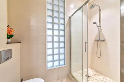 a bathroom with a shower and a toilet and a window at Elegant apartment in Nice centre with grand terrace in Nice