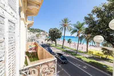 a balcony with a view of a beach and a car at MY CASA - ETATS UNIS 892 - Spacious flat on Sea front w AC in Nice