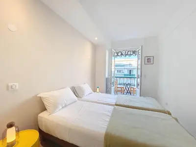 a white bedroom with a bed and a window at Nestor&Jeeves - CIEL AZUR - Terrace in Nice