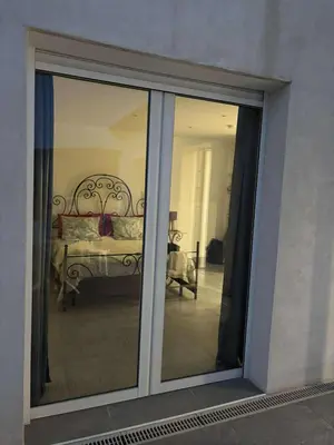 a sliding glass door with a bed in a room at Gite Mare e Montagne Drap 06 in Drap