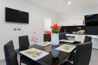a dining room with a table and chairs and a kitchen at Gite Mare e Montagne Drap 06 in Drap