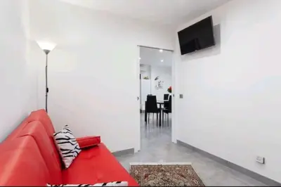 a red couch in a living room with a television at Gite Mare e Montagne Drap 06 in Drap