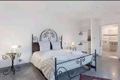 a bedroom with a large bed with a wrought iron headboard at Gite Mare e Montagne Drap 06 in Drap