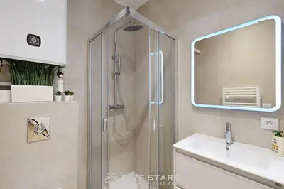 a bathroom with a shower with a sink and a mirror at Suite Gold FSHH in Nice