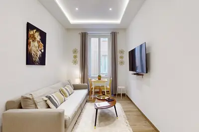 a living room with a couch and a tv at Suite Gold-Stars FSHH in Nice