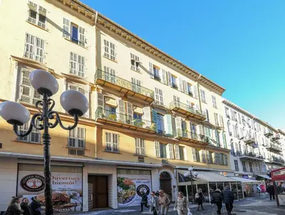 a large yellow building with people walking in front of it at Suite Gold-Stars FSHH in Nice
