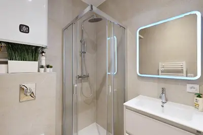 a bathroom with a shower with a sink and a mirror at Suite Gold-Stars FSHH in Nice