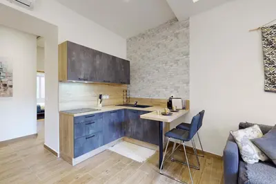 a kitchen with wooden cabinets and a table and a couch at Suite Gold-Stars FSHH in Nice