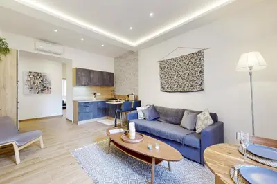 a living room with a blue couch and a table at Suite Stars FSHH in Nice
