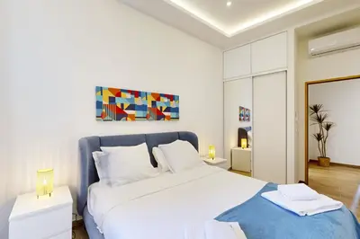 a bedroom with a large white bed with a blue blanket at Suite Stars FSHH in Nice