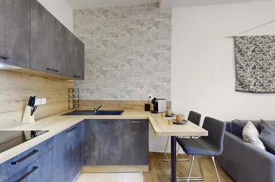 a kitchen with blue cabinets and a table with chairs at Suite Stars FSHH in Nice