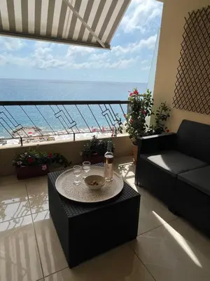 a living room with a table and a view of the ocean at Magnifique appartement avec vue sur mer in Nice
