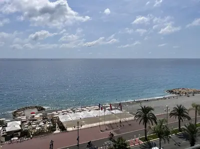 a beach with white umbrellas and the ocean at Magnifique appartement avec vue sur mer in Nice