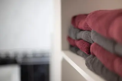 a row of red and gray towels on a shelf at Grand T1 proche Promenade des Anglais in Nice