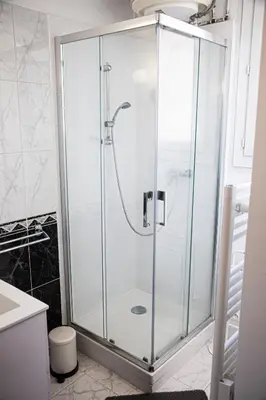 a shower with a glass door in a bathroom at Grand T1 proche Promenade des Anglais in Nice
