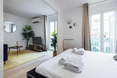 a white bedroom with a bed and a large window at Walesa- wifi, AC, 3 pers in Nice