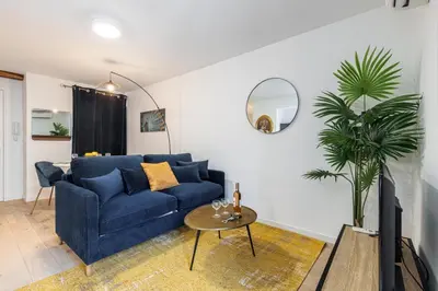 a living room with a blue couch and a table at Walesa- wifi, AC, 3 pers in Nice