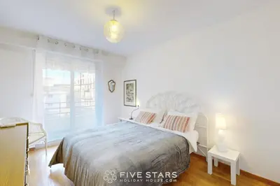 a white bedroom with a large bed and a window at Suite Aquarius FSHH in Nice