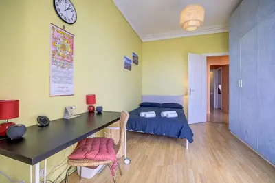 a bedroom with a desk and a bed and a clock at Maison Bianchi - 187 Promenade des Anglais - Sea view in Nice
