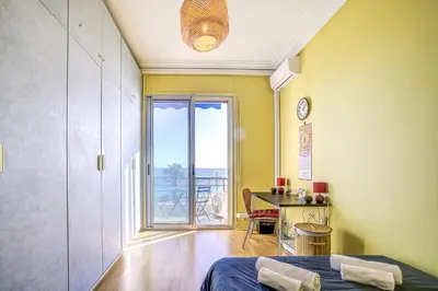 a bedroom with a bed and a large window at Maison Bianchi - 187 Promenade des Anglais - Sea view in Nice