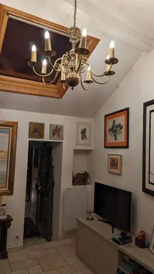 a living room with a chandelier and a flat screen tv at Maison de 6 pièces au coeur du village d'Eze in Èze