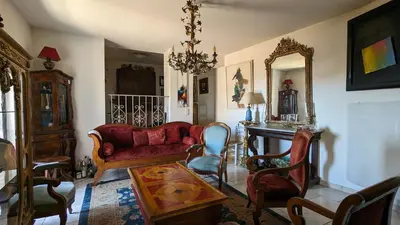 a living room with a red couch and a table at Maison de 6 pièces au coeur du village d'Eze in Èze