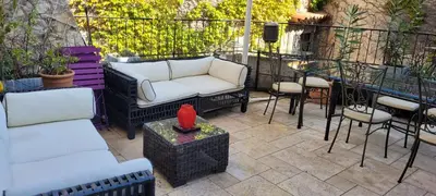 a patio with couches and a table and chairs at Maison de 6 pièces au coeur du village d'Eze in Èze