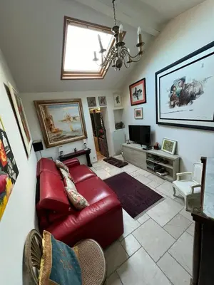 a living room with a red leather couch and a tv at Maison de 6 pièces au coeur du village d'Eze in Èze