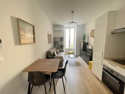 a living room with a table and a couch at COMBOUL in Nice
