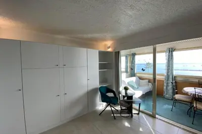 a bedroom with a bed and a room with a view of the ocean at 06BH - Beautiful seafront studio in Saint-Laurent-du-Var