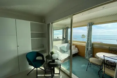 a bedroom with a view of the ocean from a window at 06BH - Beautiful seafront studio in Saint-Laurent-du-Var
