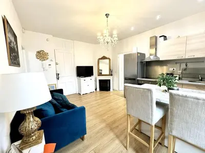 a living room with a blue couch and a table at Lumineux appartement deux pièces in Nice