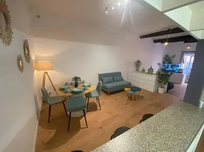 a living room with a table and chairs and a couch at Loft - centre historique in Villefranche-sur-Mer