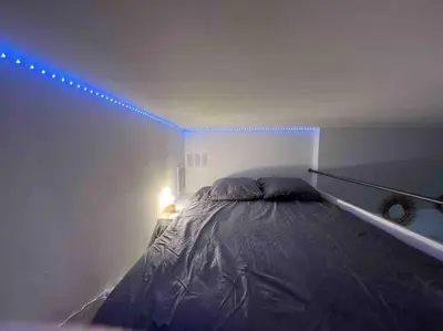 a bedroom with a bed with a blue light at Loft - centre historique in Villefranche-sur-Mer