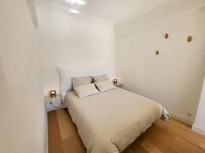 a white bedroom with a bed with two pillows at #TheCosyStudio06 Meyerbeer Promenade Negresco in Nice