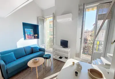 a living room with a blue couch and a large window at Nestor&Jeeves - ECLAT NICOIS - Central - Near beach in Nice