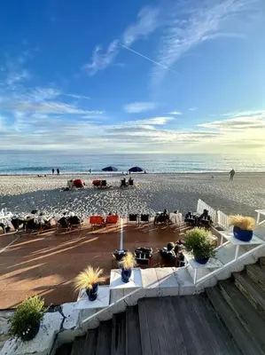 a beach with chairs and people on the beach at La Tanière du Bois Flotté in Nice