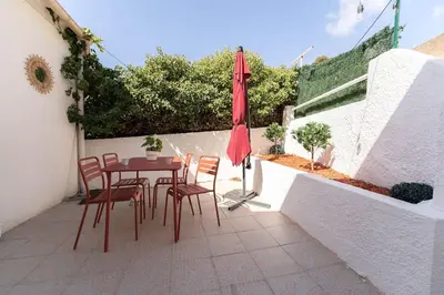 a patio with a table and chairs and an umbrella at La Tanière du Bois Flotté in Nice