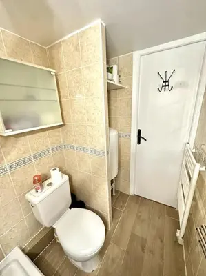 a bathroom with a toilet and a white door at La Tanière du Bois Flotté in Nice