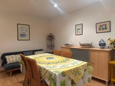 a dining room with a table and a couch at Le ville franche in Villefranche-sur-Mer