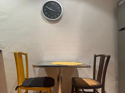 a table with two chairs and a clock on a wall at Le ville franche in Villefranche-sur-Mer