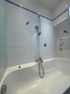 a bath tub with a shower in a bathroom at Le ville franche in Villefranche-sur-Mer