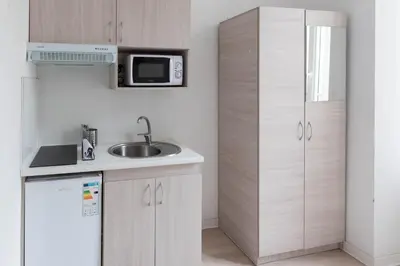 a small kitchen with a sink and a microwave at Résidence de l'Alliance in Nice
