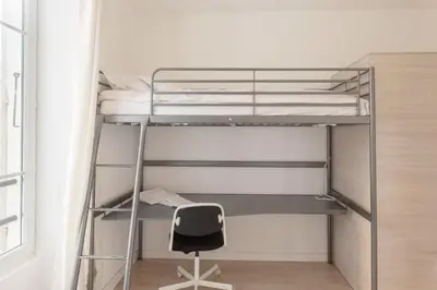 a bunk bed with a chair in a room at Résidence de l'Alliance in Nice