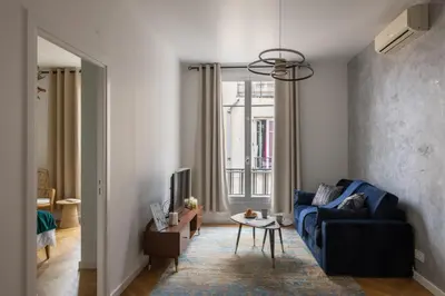 a living room with a blue couch and a tv at Serenity chic apartment Nice center in Nice
