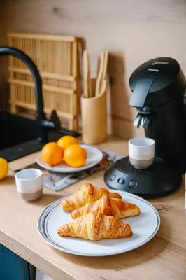 two plates of pastries on a counter with oranges at Serenity chic apartment Nice center in Nice