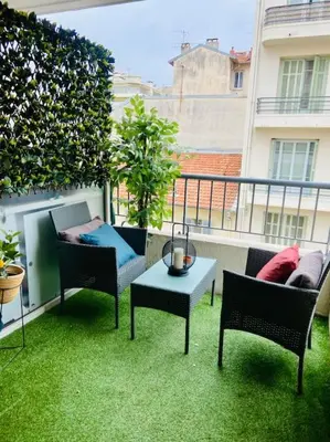 a balcony with chairs and a table on the grass at Bottero-Joli Studio avec terrasse 5 mins de la mer in Nice