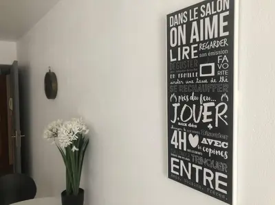 a poster hanging on a wall with a vase of flowers at Bottero-Joli Studio avec terrasse 5 mins de la mer in Nice